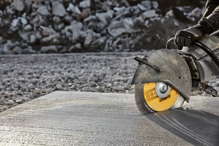 A perspective action shot of the DEWALT DW4741T blade mid-cut in a thick concrete block. The shot highlights the stability of the high-strength steel core and the efficiency of the turbo segmented rim as it maintains a straight, professional-grade path through abrasive masonry materials.