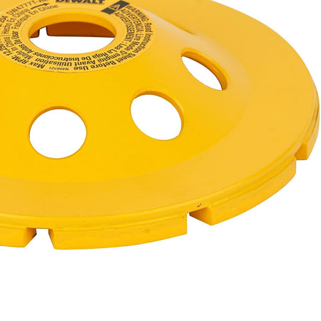 Close-up angled view of the back of the yellow DEWALT DW4777T 5-inch XP turbo diamond cup wheel, displaying cooling holes and manufacturer specifications for heavy-duty concrete and masonry surface prep.