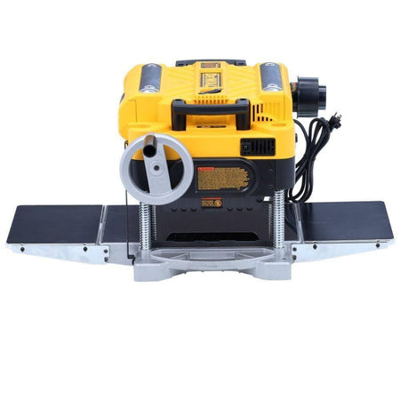 Front eye-level view of the planer showing the material removal gauge, depth adjustment crank handle, and the open throat for feeding lumber.