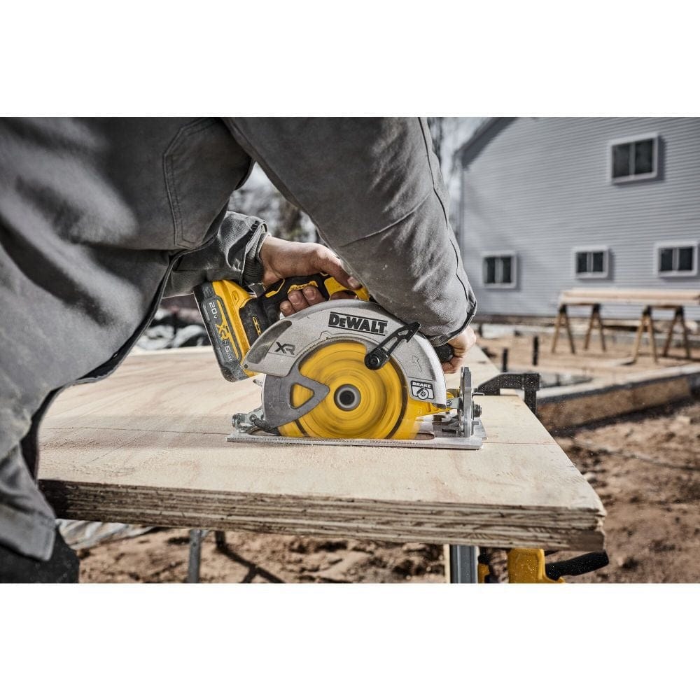 Perspective action shot of a professional at a residential construction site using a circular saw to precisely cut a sheet of plywood on a workbench.
