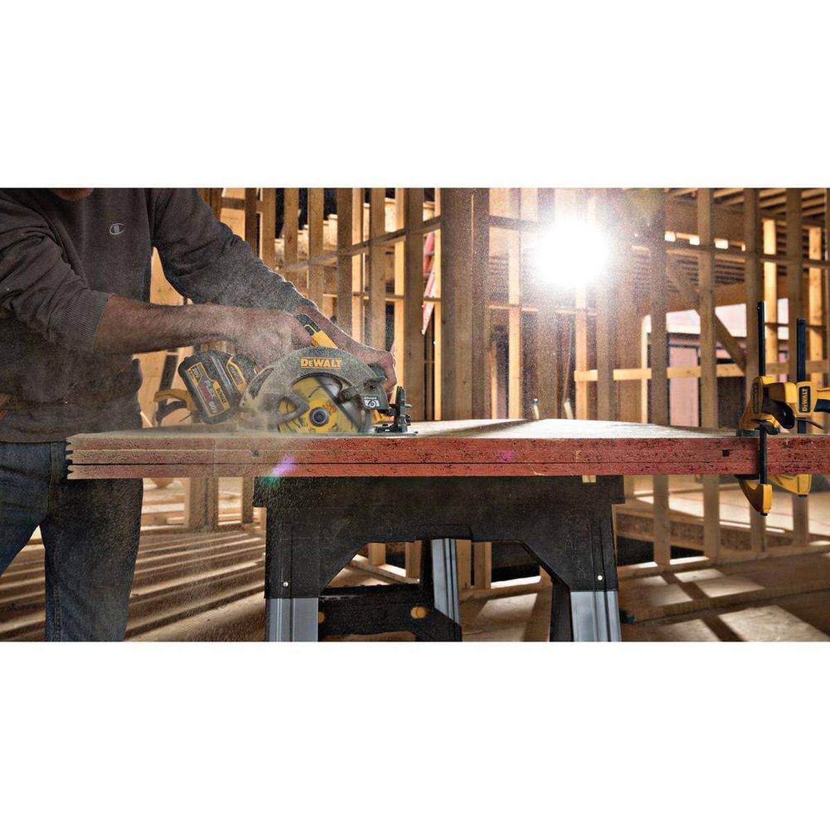 An action shot of a worker using a cordless circular saw equipped with the DEWALT DWAFV37243 blade to rip through a stack of plywood sheets. The sunlit construction background emphasizes the tool's portability and the blade's thin-kerf design for smooth material removal in high-volume framing tasks.