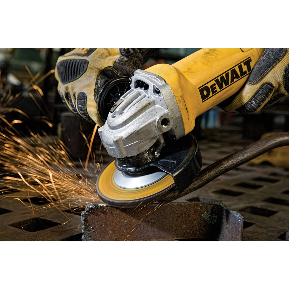 A high-intensity action shot of the DEWALT 11-Amp grinder in use on a metal fabrication project. The image emphasizes the tool's durability and power as it generates a steady stream of sparks during heavy stock removal on ferrous materials.