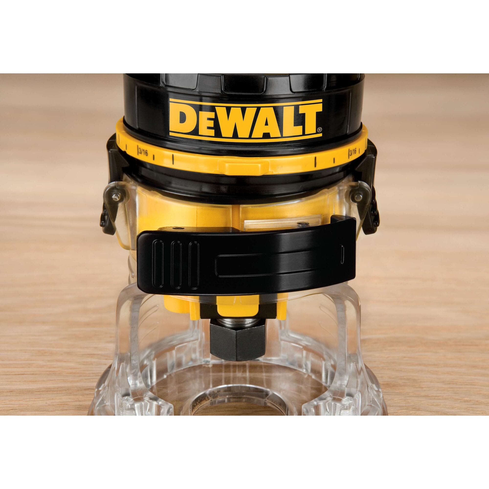 Close-up of the DEWALT DWE6000 clear sub-base and 1/4-inch collet assembly, highlighting the heavy-duty locking clips used for quick motor release and coarse depth adjustments on the jobsite.