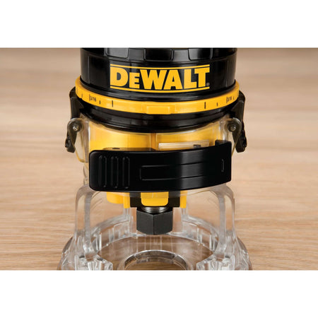 Close-up of the DEWALT DWE6000 clear sub-base and 1/4-inch collet assembly, highlighting the heavy-duty locking clips used for quick motor release and coarse depth adjustments on the jobsite.