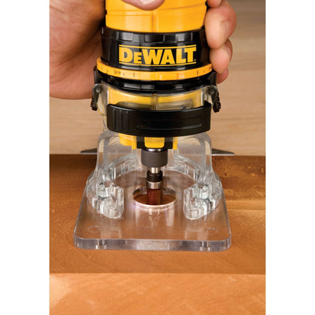 The DEWALT DWE6000 31,000 RPM Router in use for edge forming, highlighting how the clear base allows the operator to monitor bit contact with the workpiece for professional-grade finishing.