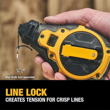 Close-up action shot showing a hand holding the chalk reel and utilizing the line lock feature to create tension for a crisp layout line on a wooden surface.