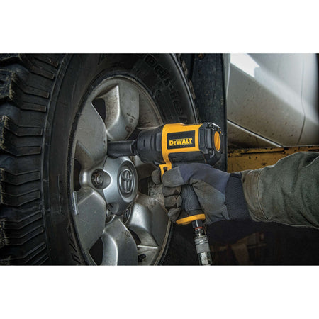 Marketing layout showing the DEWALT heavy-duty impact wrench alongside the included bottle of pneumatic air tool oil, highlighting the complete kit contents for maintaining peak tool performance and longevity.