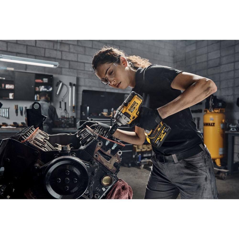 Automotive mechanic using a DEWALT deep impact socket attached to a 20V cordless impact wrench to perform heavy duty repairs on an exposed engine block.