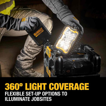 Jobsite application showing a worker adjusting a pivoting LED head on the DEWALT ToughSystem 2.0 light box to achieve 360-degree light coverage in a dim work area.