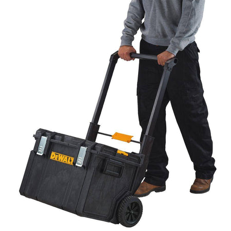 Worker transporting the DEWALT TOUGHSYSTEM 2.0 large tool box using a mobile base, demonstrating the system's 110-lb load capacity and ease of mobility.