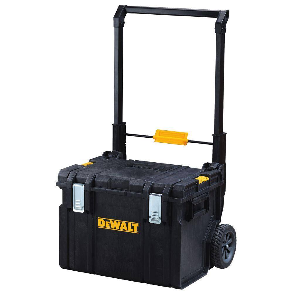 The DEWALT TOUGHSYSTEM 2.0 large storage case attached to a mobile rolling carrier with heavy-duty wheels, prepared for transport across a construction site.
