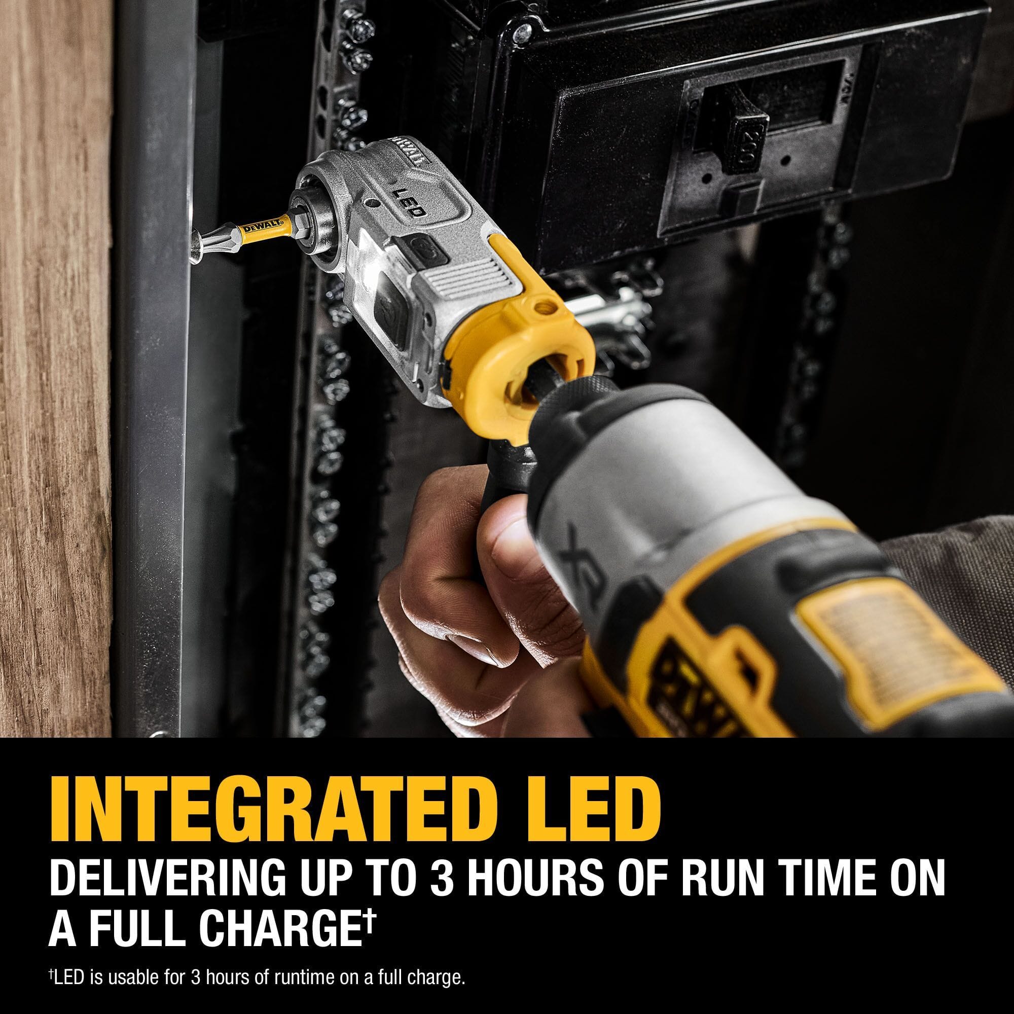 A professional using the DEWALT lighted right-angle attachment with an impact driver to fasten a screw inside a dark electrical panel, demonstrating the integrated LED visibility.