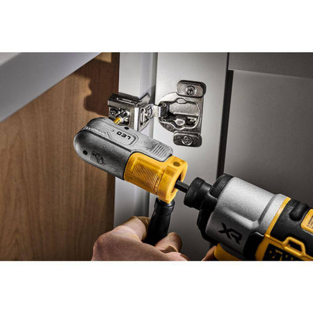 Action shot demonstrating the DEWALT modular right-angle attachment being used with a cordless impact driver to reach fasteners inside a kitchen cabinet, showcasing its compact design and modular handle.
