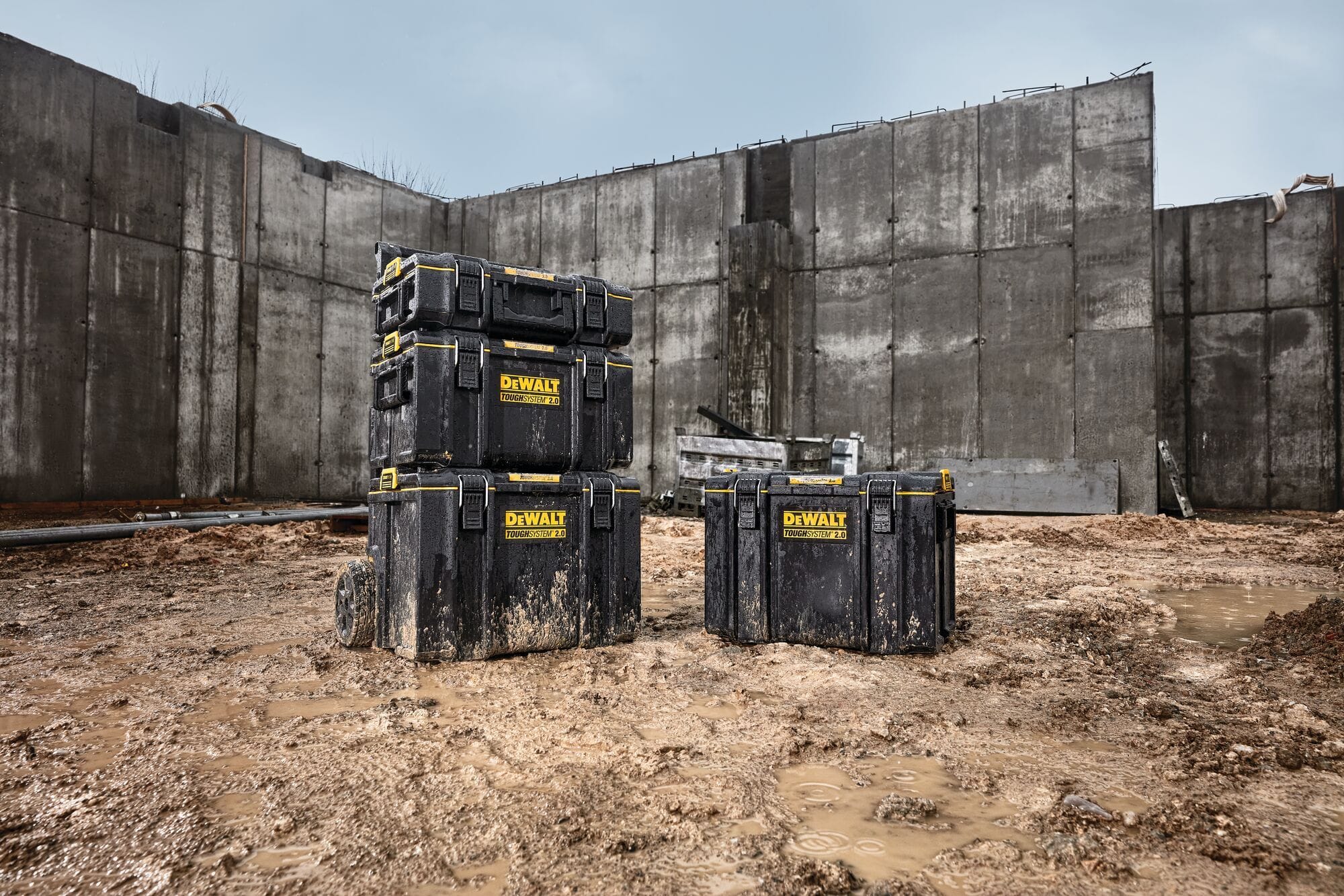 Four DEWALT ToughSystem 2.0 tool boxes placed on muddy construction ground showcasing rugged waterproof design and heavy duty durability for professional outdoor jobsite environments.