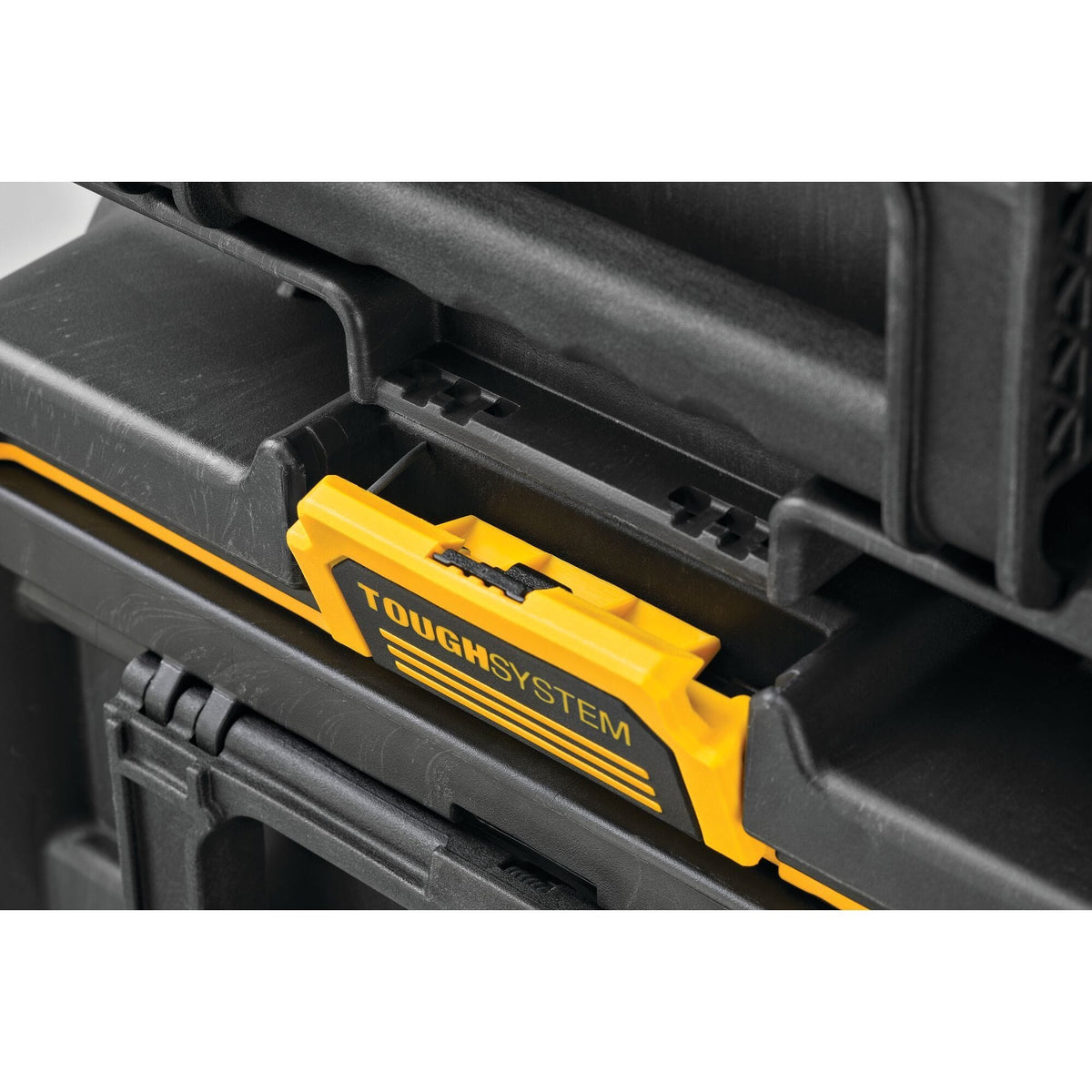Close up of DEWALT ToughSystem latch mechanism connecting stacked tool boxes highlighting rugged interlocking modular design for secure transport and professional grade tool organization.