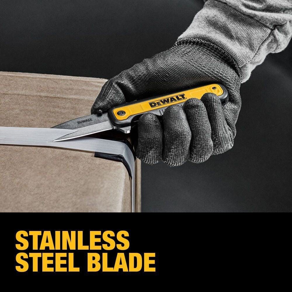 Gloved hand using DEWALT DWHT10993 utility knife with stainless steel blade to cut plastic strap on cardboard box; bold text highlights blade material.