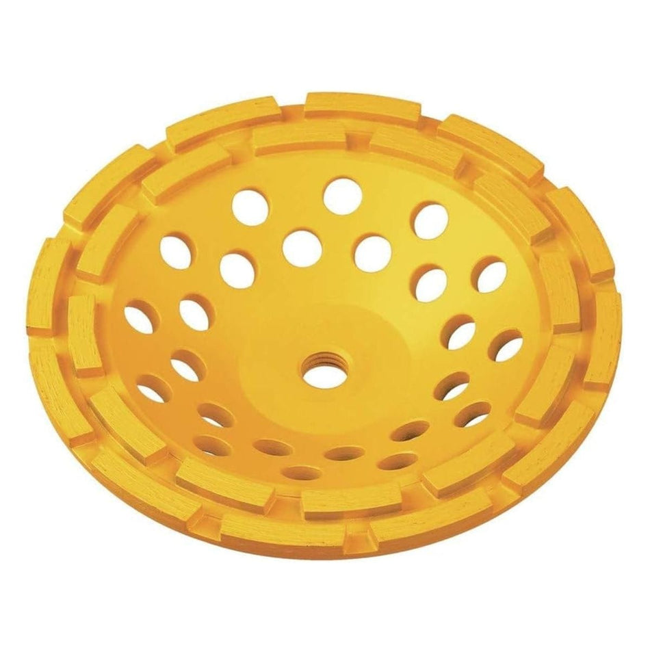 A top-down studio shot of the yellow DeWALT DW4773 7-inch double row diamond cup grinding wheel, showing the circular arrangement of large diamond grinding segments and a pattern of cooling holes.