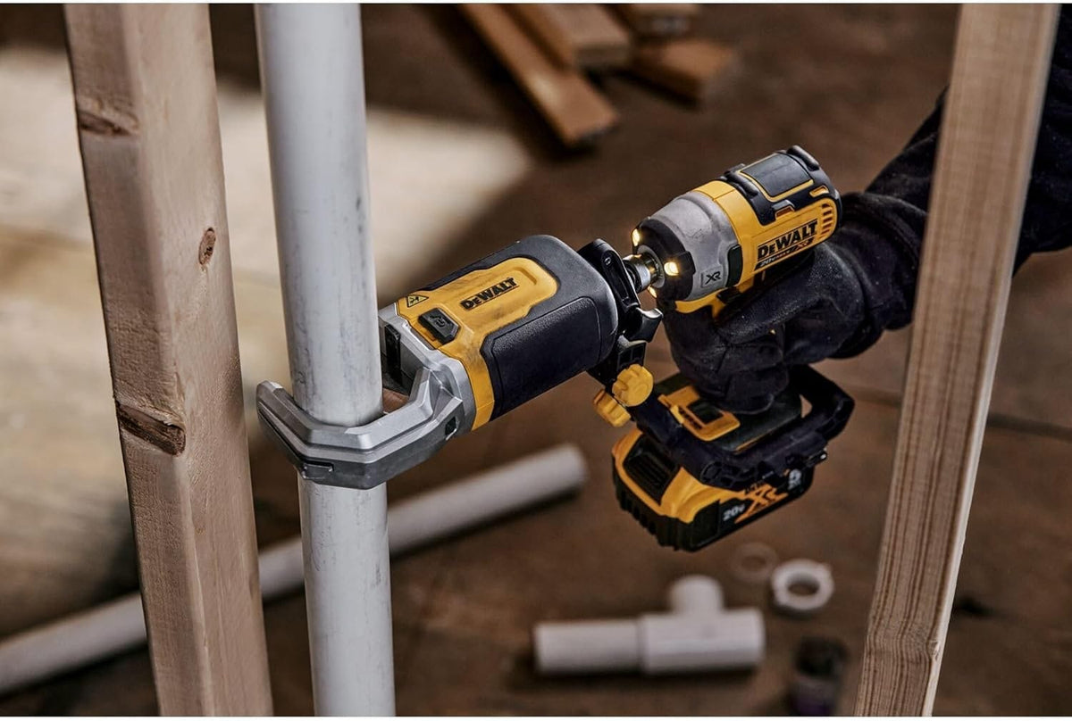 Person using a DEWALT 20V MAX XR impact driver with a right-angle attachment to fasten a bolt on a metal pipe in a tight space between wooden studs.