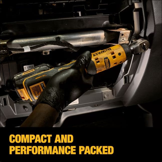 Person using DEWALT cordless ratchet wrench under a vehicle dashboard, with text “COMPACT AND PERFORMANCE PACKED” emphasizing tool’s ergonomic design.