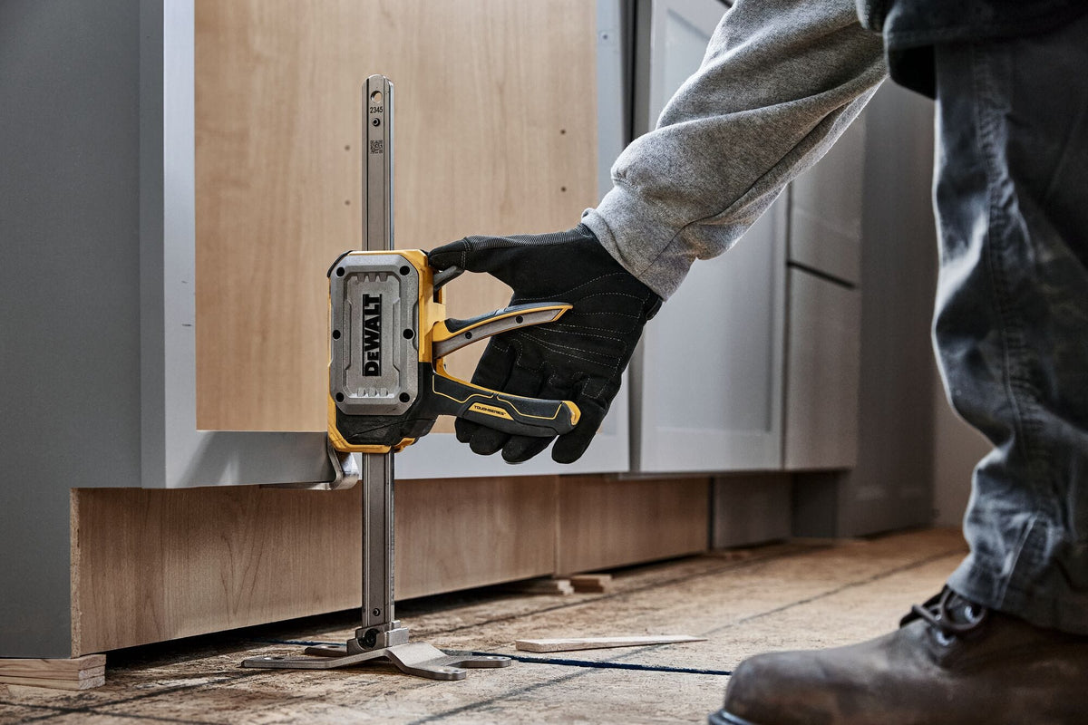 DeWalt DWHT83550 construction jack low-profile toe sliding beneath kitchen cabinet frame to make height adjustments.