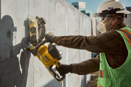 Vertical wall expansion joint cutting with the DeWalt DCS692 saw utilizing water suppression to control dust.