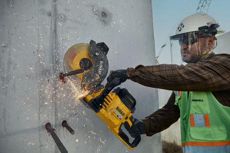 Tradesman cutting horizontal wall rebar with the DeWalt DCS692 60V cut-off saw using the ceramic metal blade.