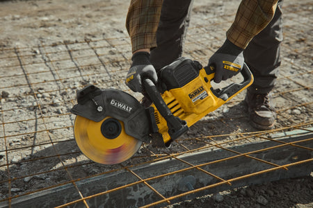 Close-up of a contractor trimming structural steel mesh on a jobsite using the DeWalt cordless cut-off saw.