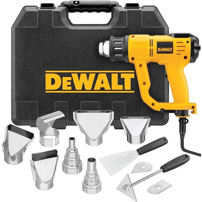 Studio view of the complete DeWalt heat gun kit, showing the black hard carrying case standing behind the yellow tool and an assortment of silver metal nozzles and scraper blades arranged in the foreground.