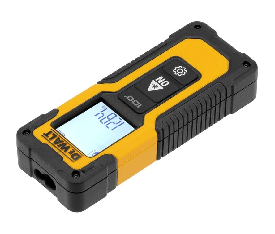 Angled view of the DeWalt laser measurer resting flat, showing the front laser aperture, black rubberized side grips, and the digital screen displaying a measurement of 12.84 ft.