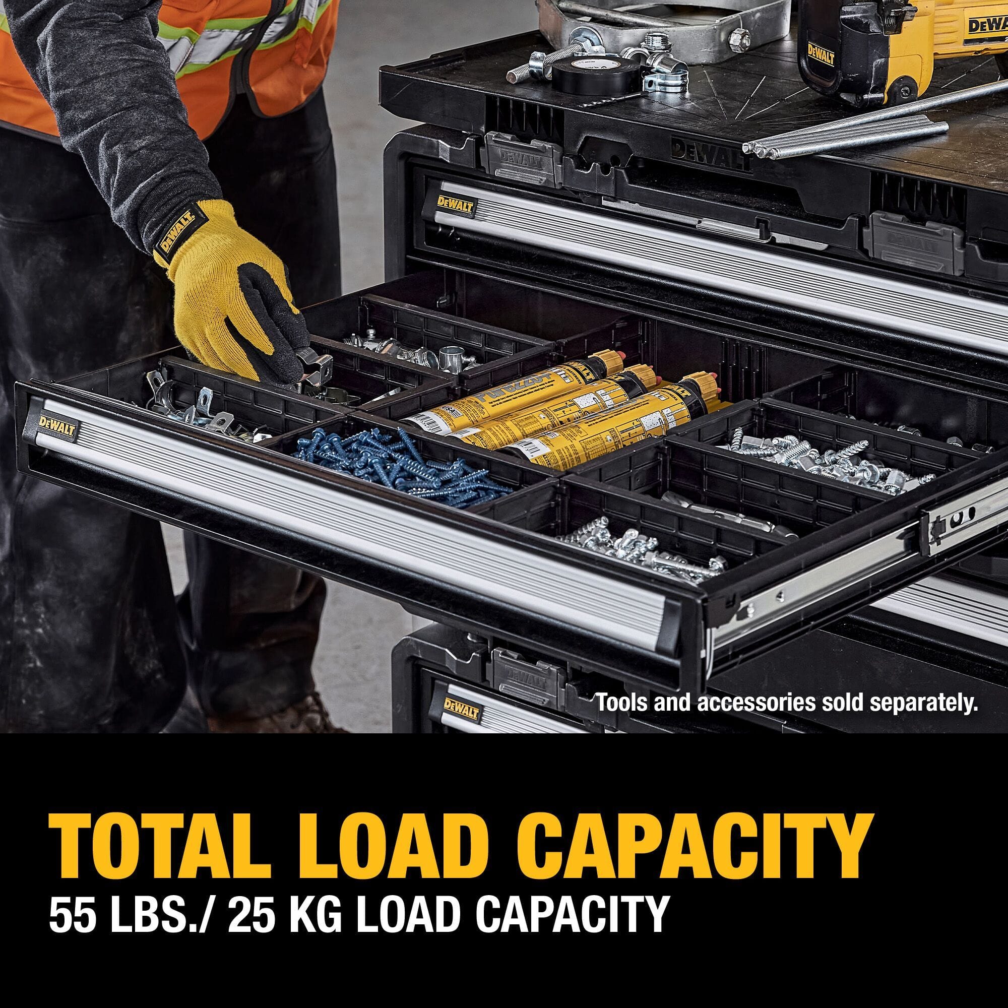 A close-up lifestyle product photo of a construction worker wearing high-visibility yellow protective gloves and safety gear as he reaches into an open yellow drawer organizer compartment packed with sorting bins containing structural screws, bolts, and caulking cartridges, with lower text stating TOTAL LOAD CAPACITY 55 LBS. / 25 KG LOAD CAPACITY.
