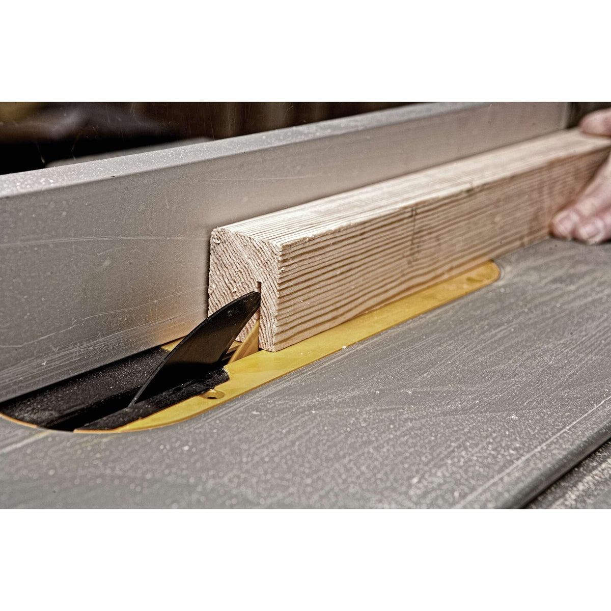 Making a dado groove pass on a wood post using a dado blade set on the DeWalt DWE7491RS table saw.
