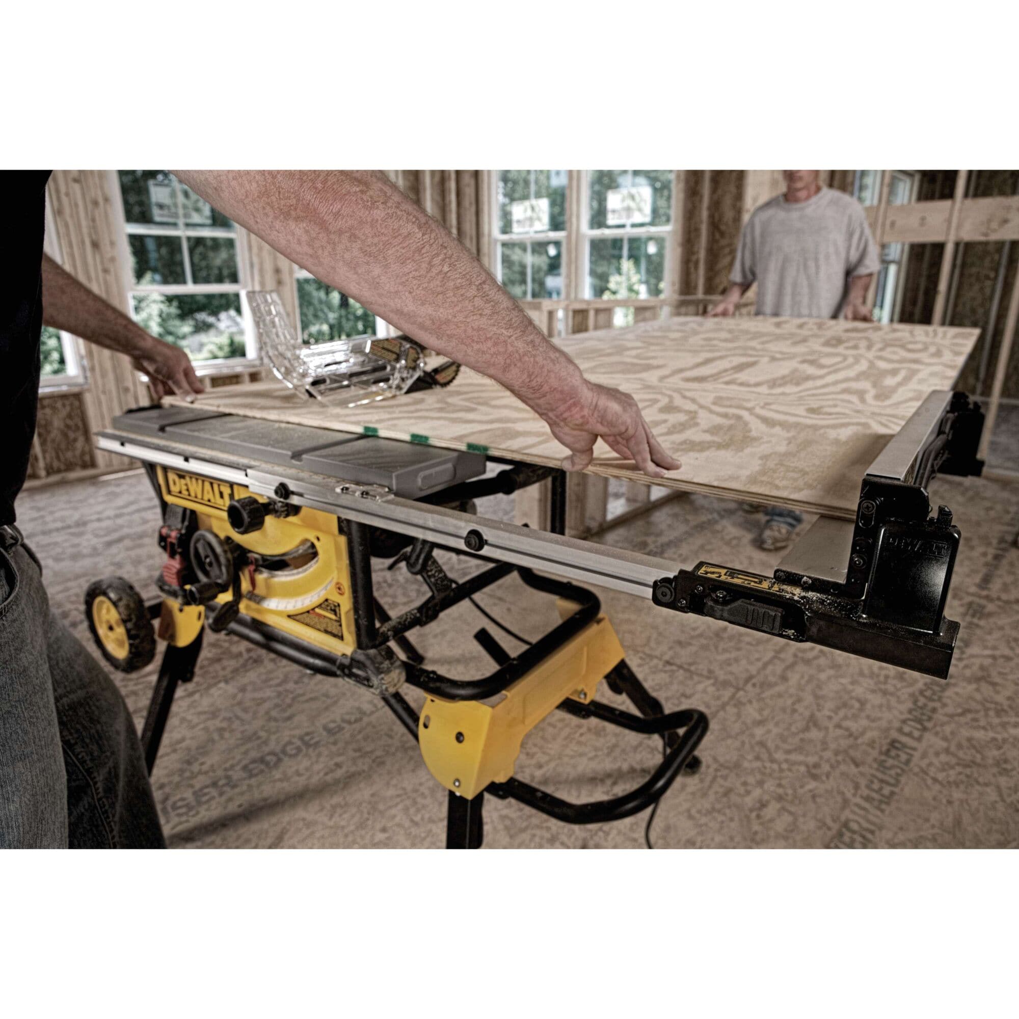 Woodworker feeding a large plywood sheet through the DeWalt DWE7491RS table saw utilizing its 32-1/2-inch rip capacity.