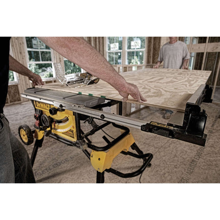 Woodworker feeding a large plywood sheet through the DeWalt DWE7491RS table saw utilizing its 32-1/2-inch rip capacity.