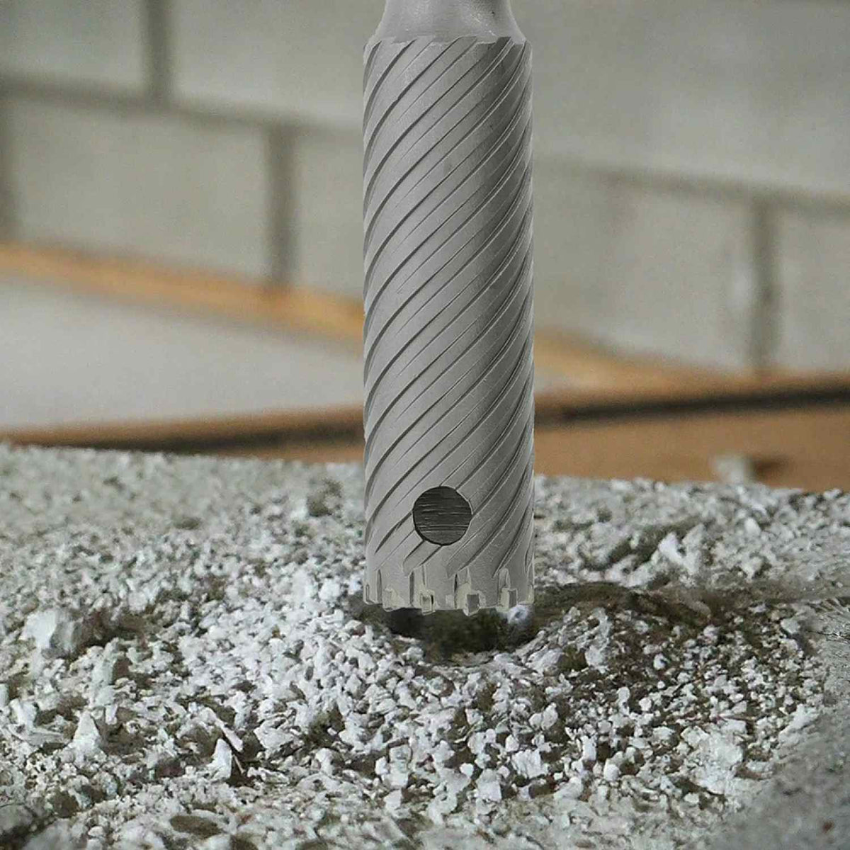 Diablo 1-1/2 inch rebar cutter in operation drilling into a concrete surface and effectively removing dust through the optimized flute design.