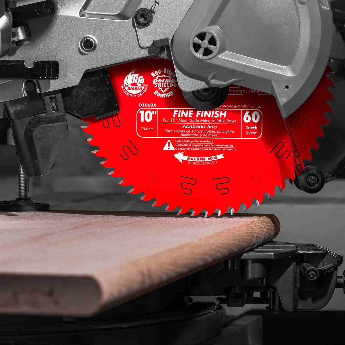 Close-up of a red Diablo circular saw blade mounted on a miter saw, positioned near a wood board, showing blade specifications and setup for precise cutting