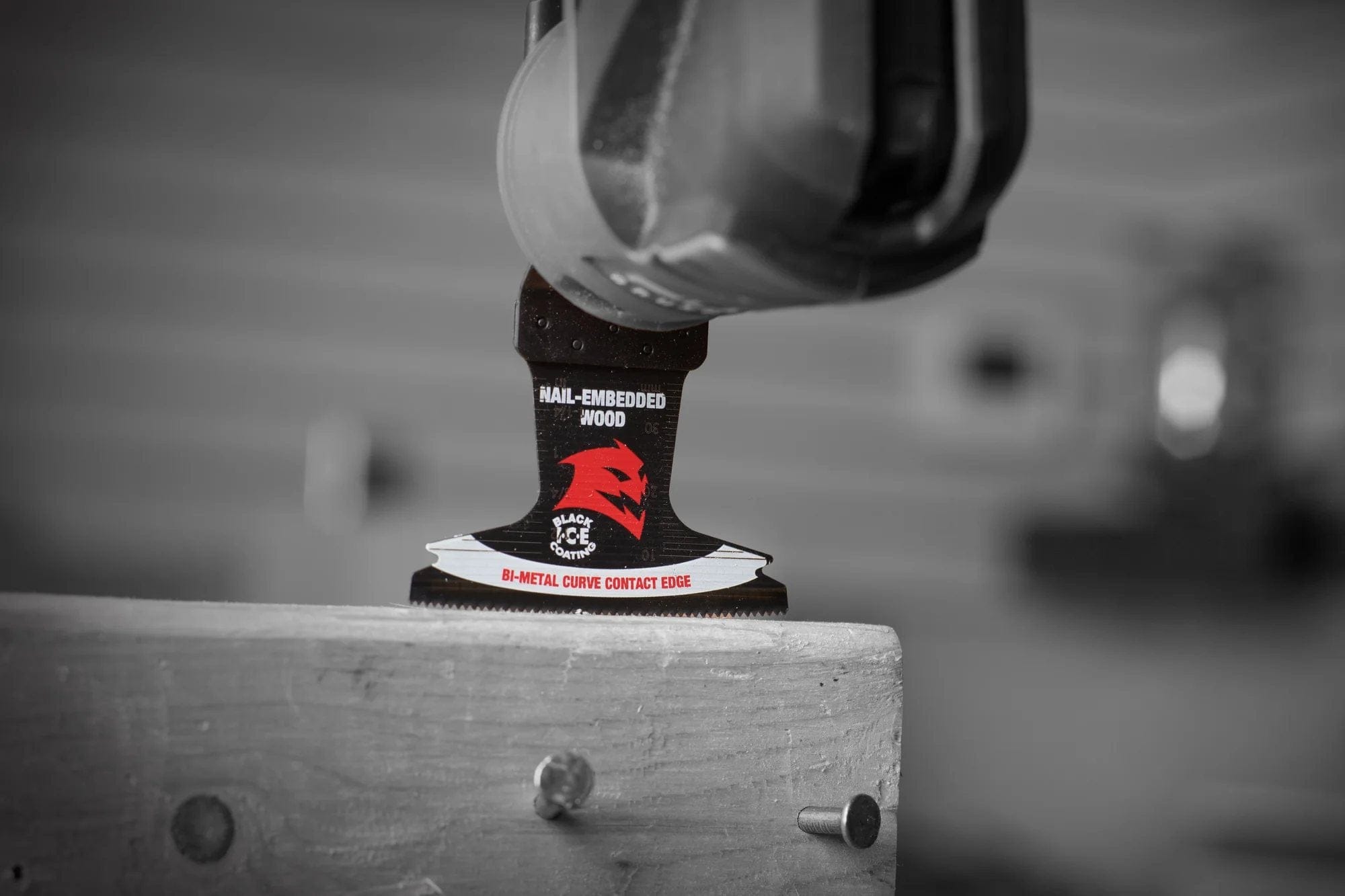 Action shot of a Diablo Demo Demon oscillating blade attached to a multitool performing a precise plunge cut into a wood beam with embedded metal nails.