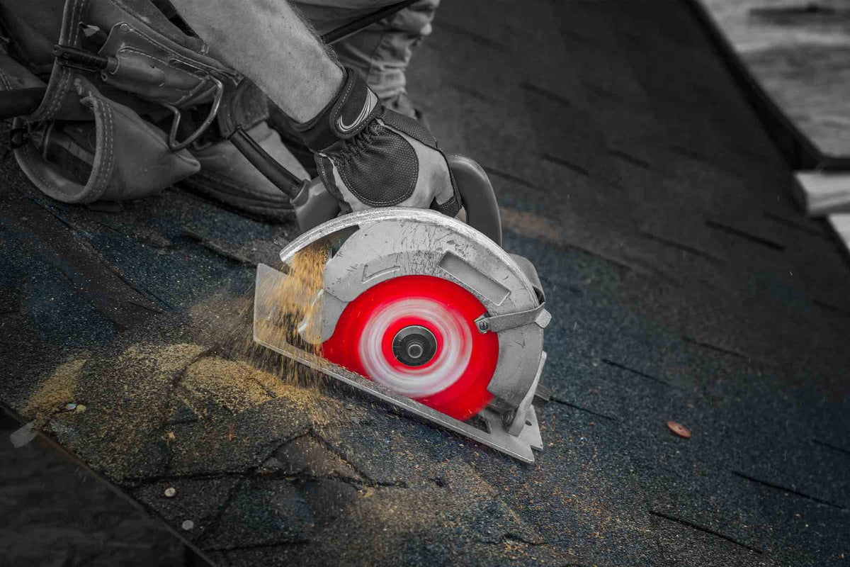 An action shot showing a professional using a circular saw equipped with a Diablo D0724DA Demo Demon blade to cut through abrasive roofing shingles, demonstrating the blade's high-impact demolition performance.