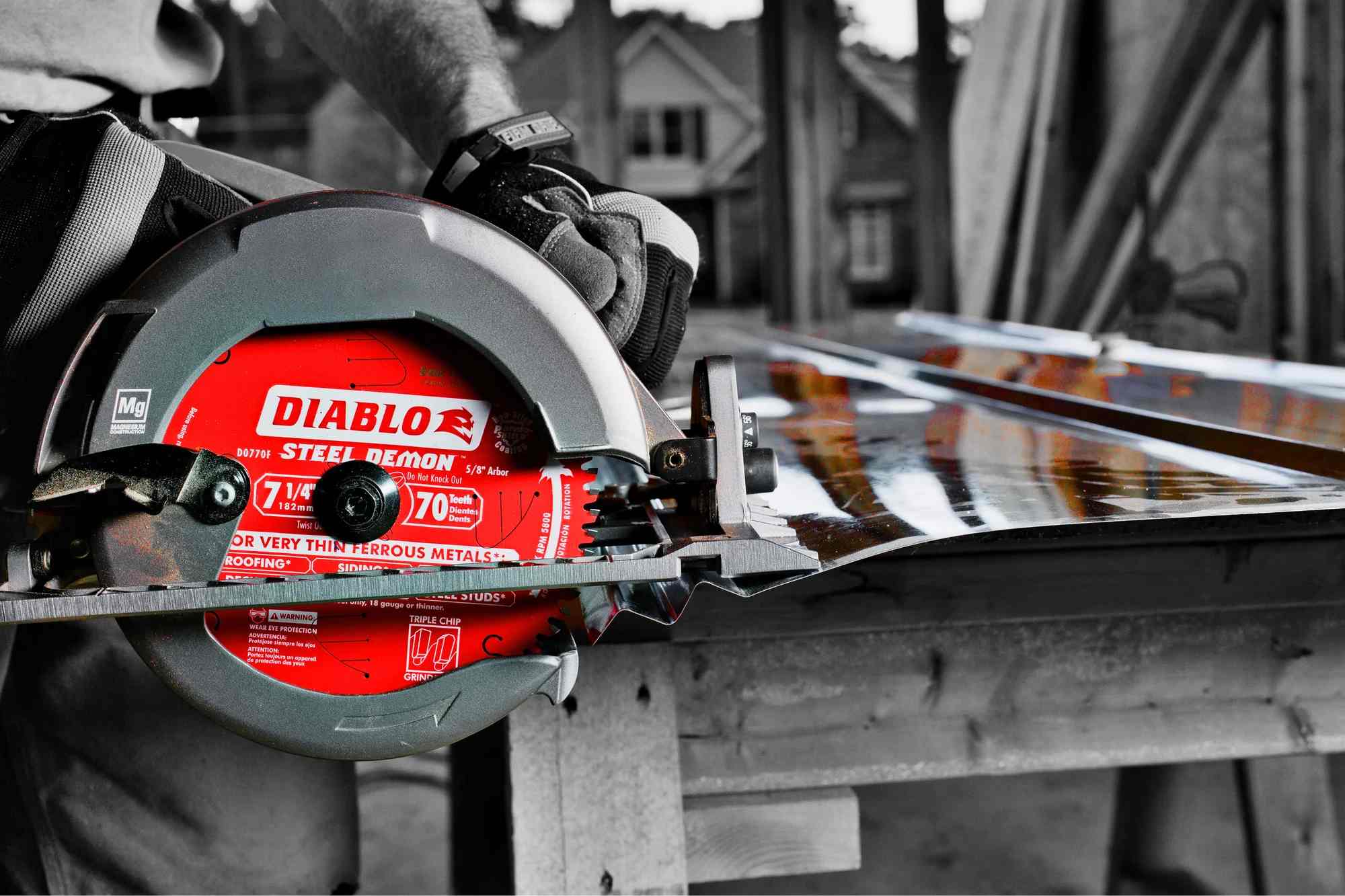 Close-up action shot of a professional circular saw utilizing a Diablo Steel Demon blade to make a clean, burr-free cut through a corrugated metal roofing panel.