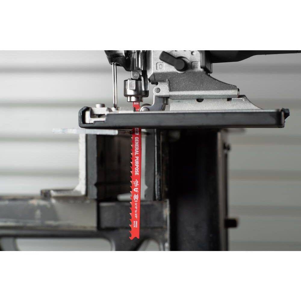 Action shot of a Diablo red general purpose bi-metal jig saw blade installed in a power tool, demonstrating a precise vertical cut through an industrial metal workpiece.