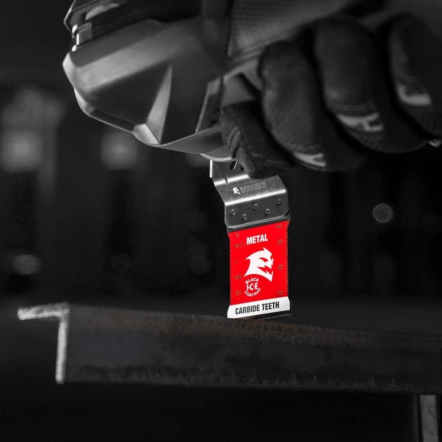 An action shot of a professional wearing a black work glove using an oscillating multi-tool equipped with a red Diablo carbide blade to plunge-cut through a gray metal L-beam.