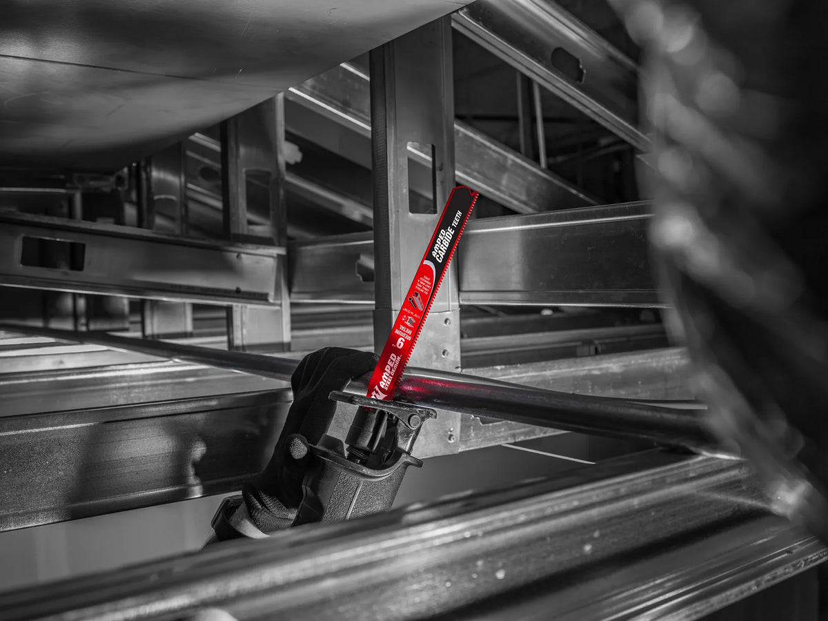 An on-site construction application shot of an operator using a cordless reciprocating saw with a red Diablo AMPED carbide blade to execute a precise, overhead plunge cut through an unistrut metal framing pipe setup.