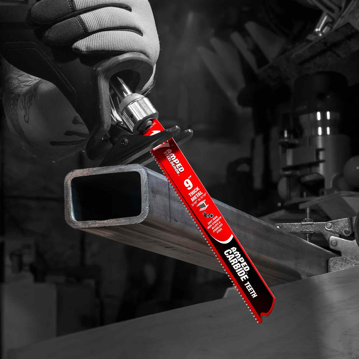 An action photograph of a 9 inch Diablo AMPED Steel Demon carbide blade in a reciprocating saw cutting through a thick-walled rectangular metal tube, demonstrating the blade's industrial-grade performance and heat resistance in heavy-duty fabrication.