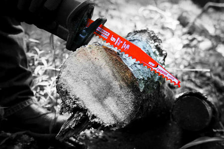 A second action photograph showing the Diablo carbide teeth pruning blade cutting through a thick tree trunk, illustrating the depth of cut provided by the 12 inch length and the blade's stability in heavy wood.