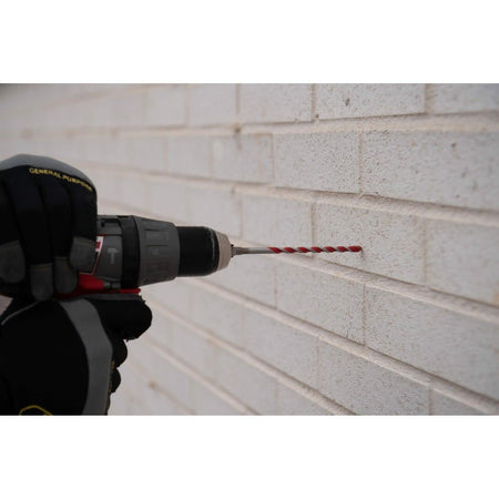 Drill bit being used on a brick wall