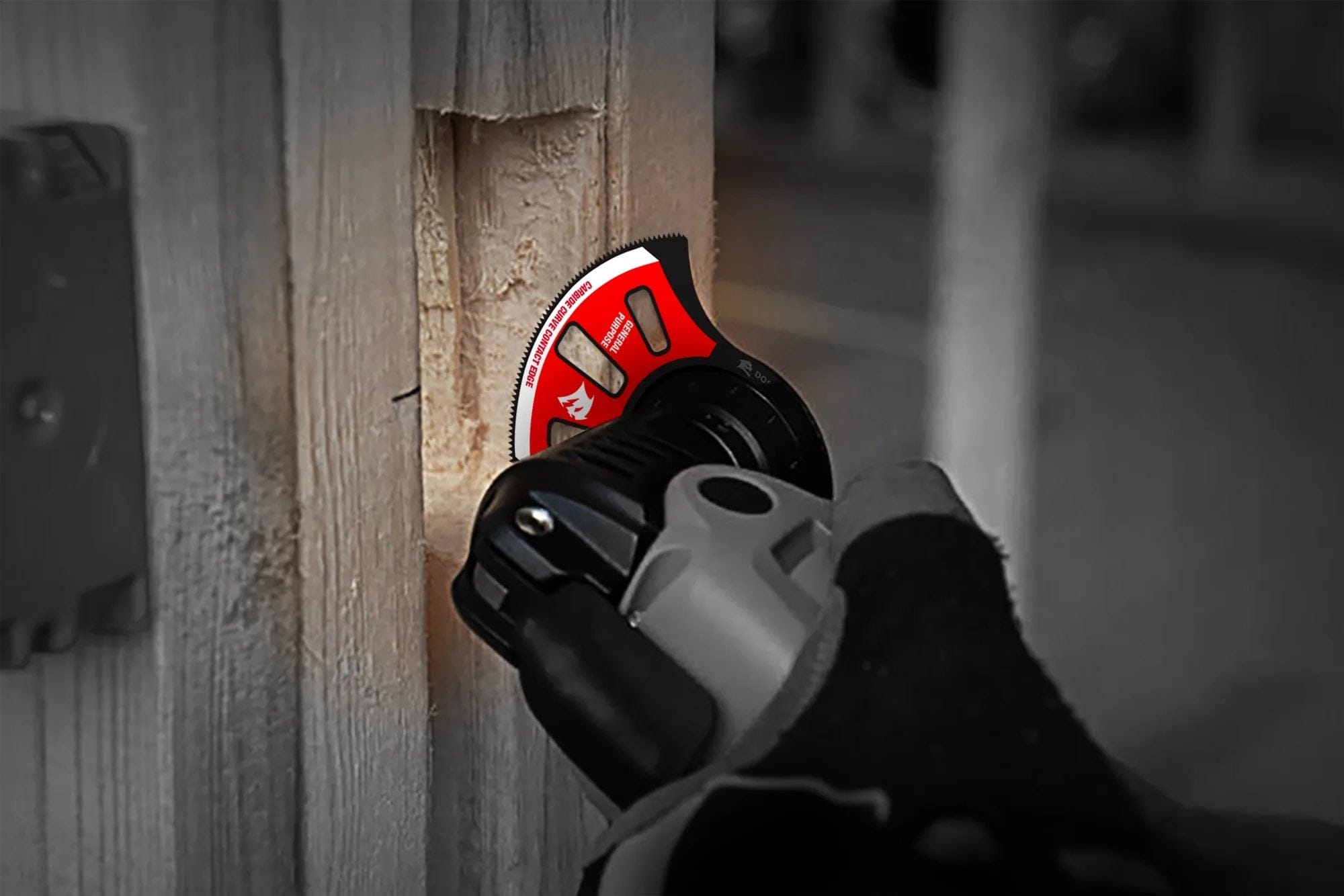 An action photograph of the Diablo Starlock carbide oscillating blade performing a clean plunge cut into a wooden frame, demonstrating the effectiveness of the Curve Contact Edge.