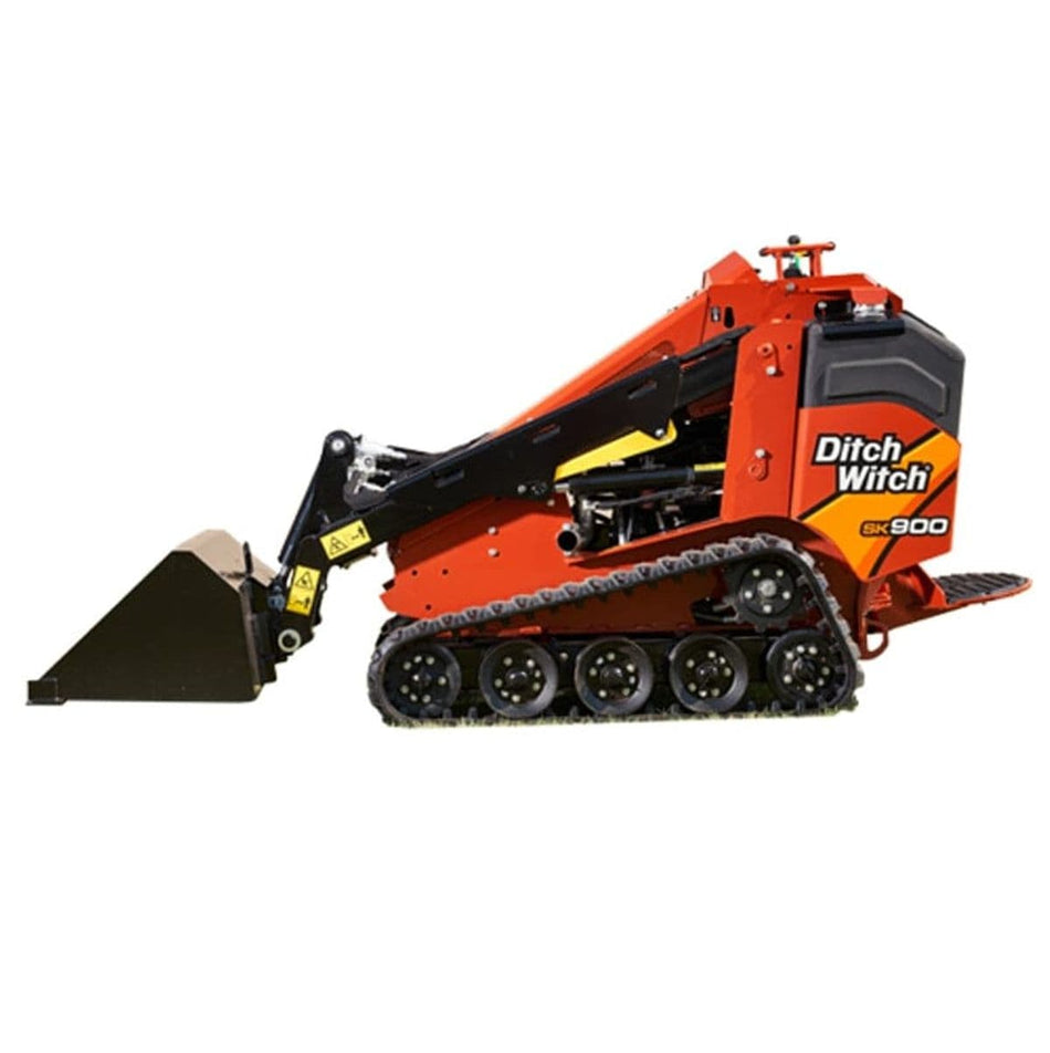 Compact Ditch Witch SK900 mini skid steer loader parked on a job site, featuring rubber tracks, front-mounted bucket, and hydraulic arms; designed for landscaping, construction, and tree care tasks. Branding is visible on the side of the machine.