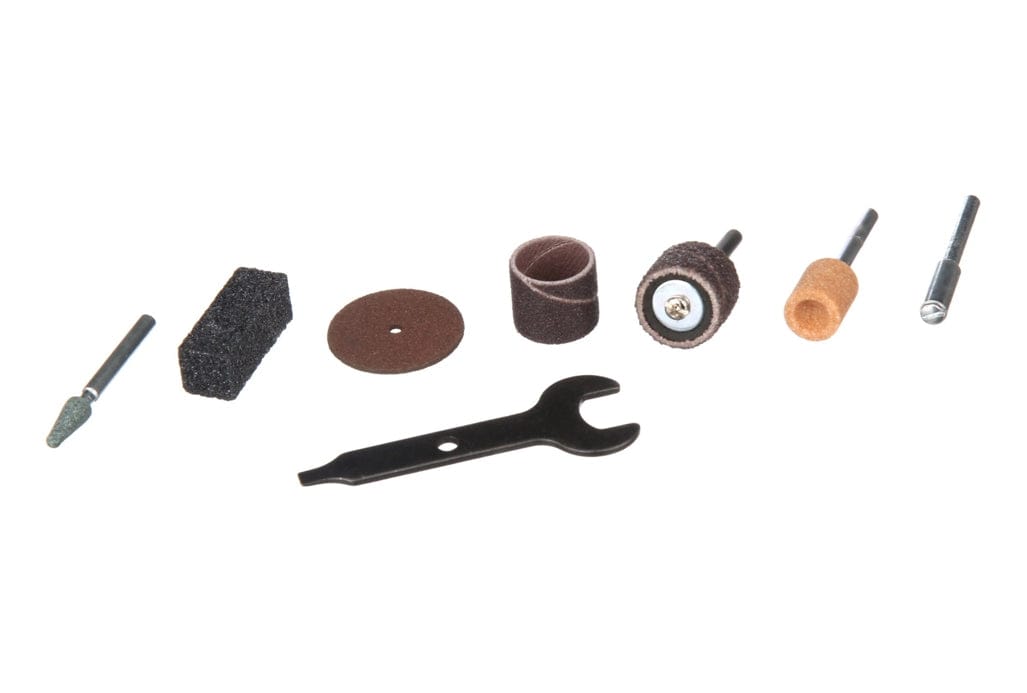 A studio shot of the 7 accessories included in the Dremel 100-N/7 kit, including grinding stones, sanding bands, a cut-off wheel, and a wrench, all laid out on a white background.