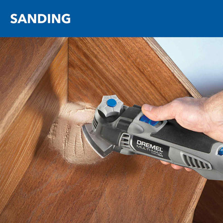 Close-up of the Dremel MM50 in use for detail sanding in the sharp corner of a wooden step, illustrating the reach and control of the triangular sanding attachment.