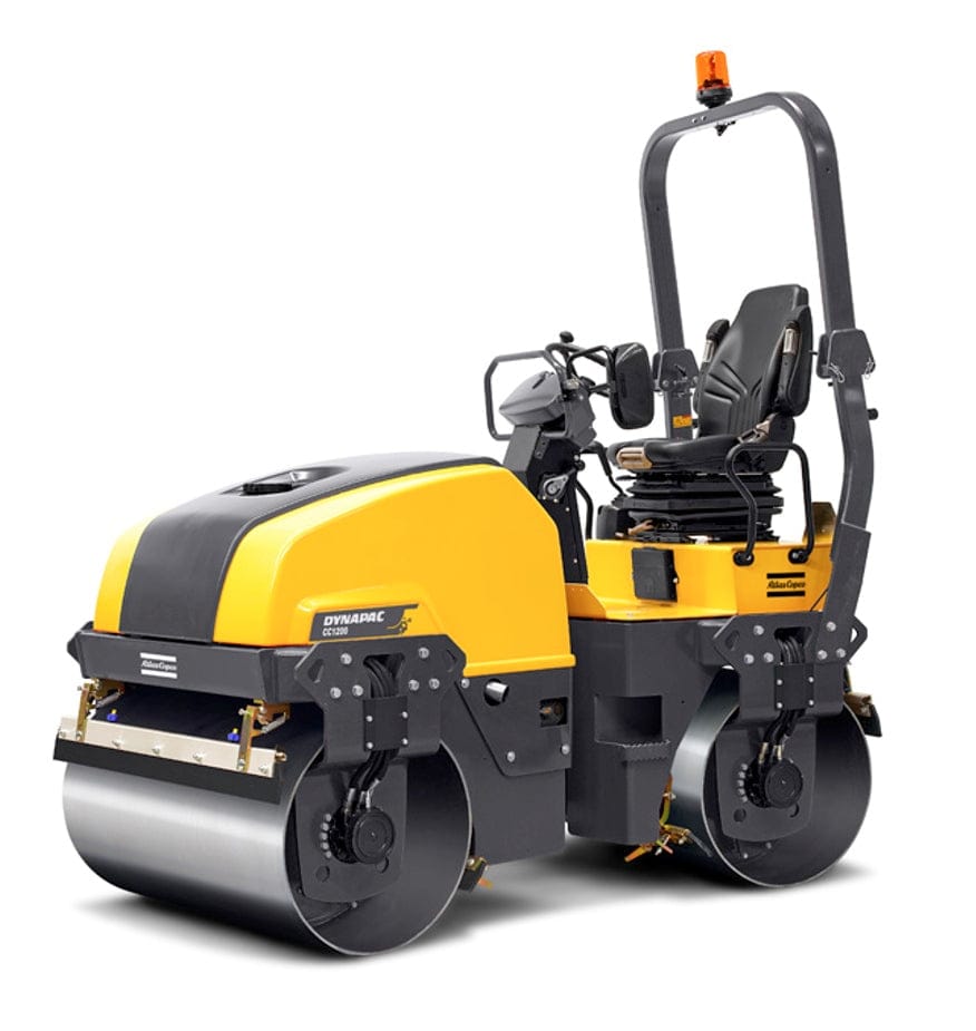 Dynapac CC1200 yellow and black tandem vibratory roller with front and rear steel drums, operator seat, control levers, and roll-over protection frame, designed for compacting asphalt and soil in roadwork and urban construction.
