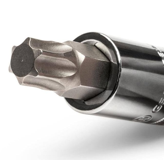 A close-up studio shot of a Tamper Proof Torx bit inserted into a chrome socket holder, showing the security hole in the center of the bit.